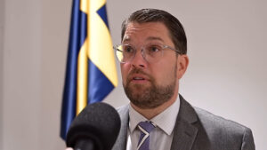 A group of politicians from the Sweden Democrats party, led by Jimmie Åkesson, standing together at a podium during a political rally